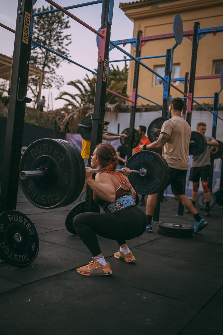 CrossFit athlete squatting with a barbell in the outdoor training area