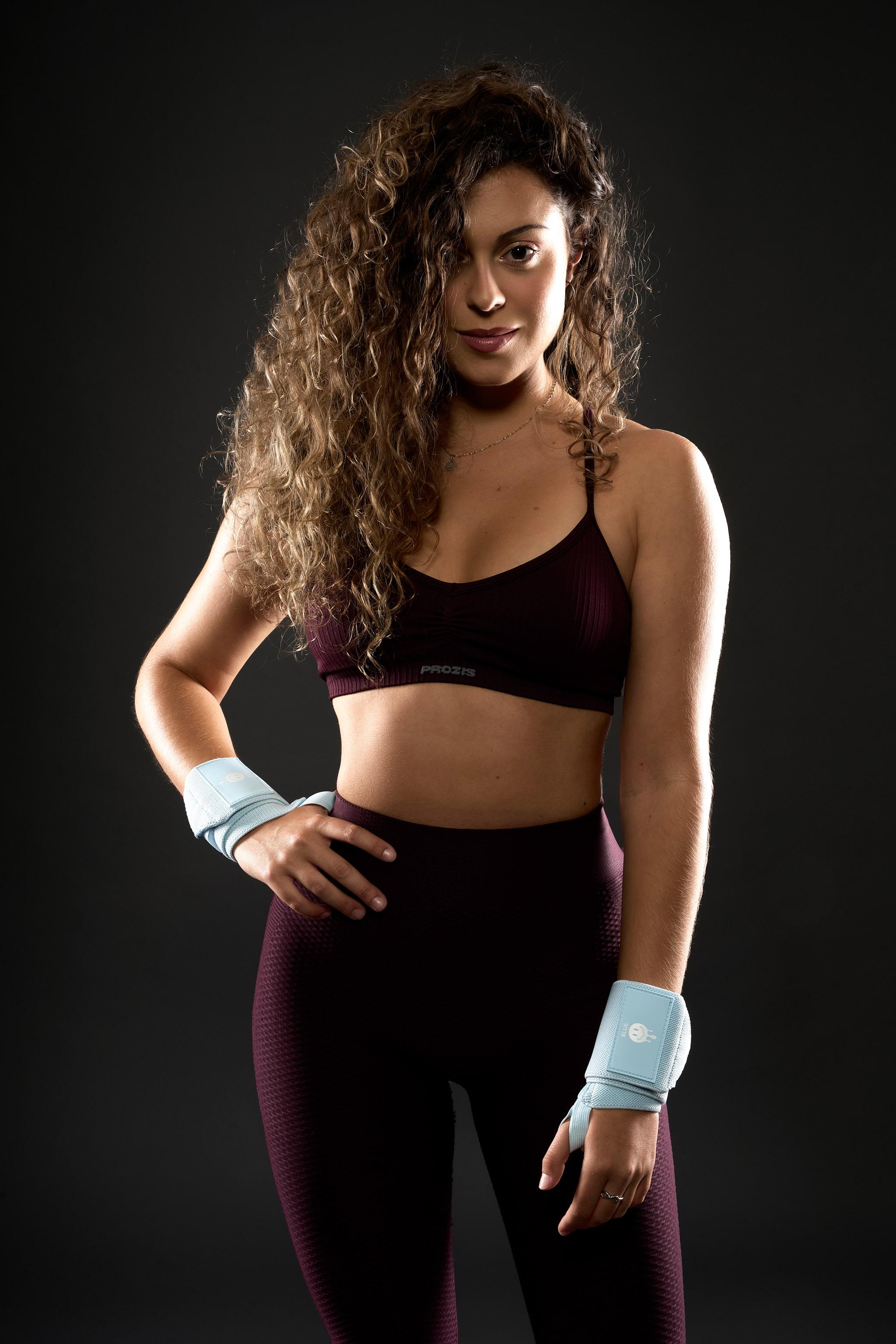 Curly-haired athlete wearing light-blue BLUE wrist wraps